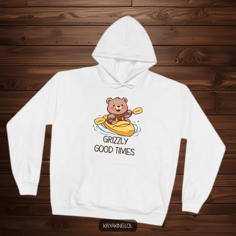 Funny hoodie with a brave bear smiling while attempting a risky kayak roll, showcasing adventurous spirit.
