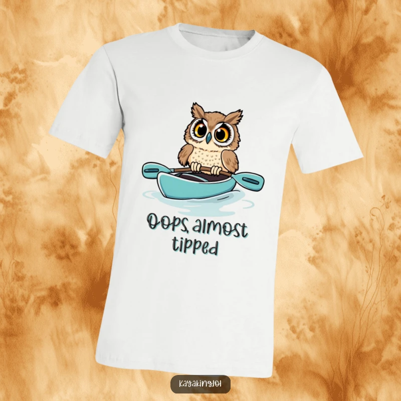 Funny owl t-shirt showing a startled bird in a kayak, its eyes exaggeratedly wide as it struggles to balance, a humorous wildlife scene.